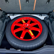 This is a close-up of the Spare tire fitted inside the wheel well of the 2025 Genesis GV80, perfectly matching the storage space.