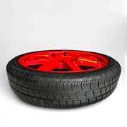Low-profile 20-inch spare wheel with a high-performance tire and a striking red alloy rim, designed for quick and stylish emergency replacement, showcased on a white gradient background.
